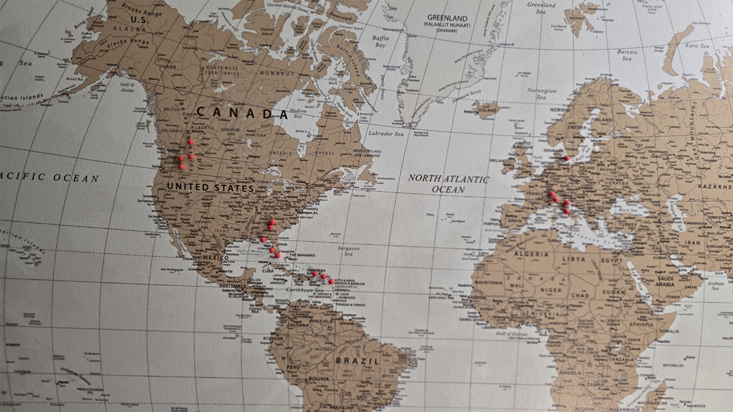 Our world map with red pins marking the places we've been
